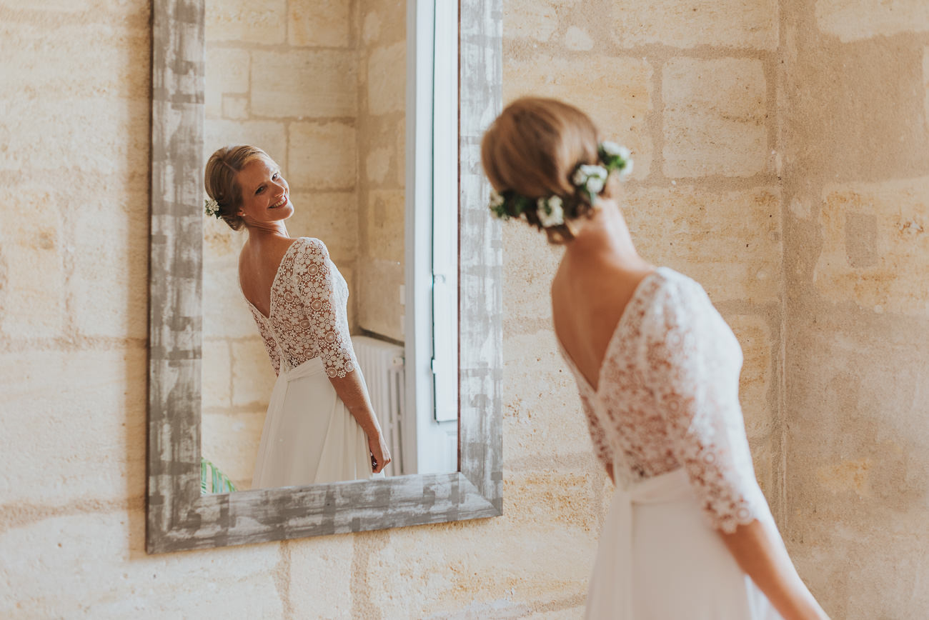 Mariée heureuse qui se regarde dans le miroir