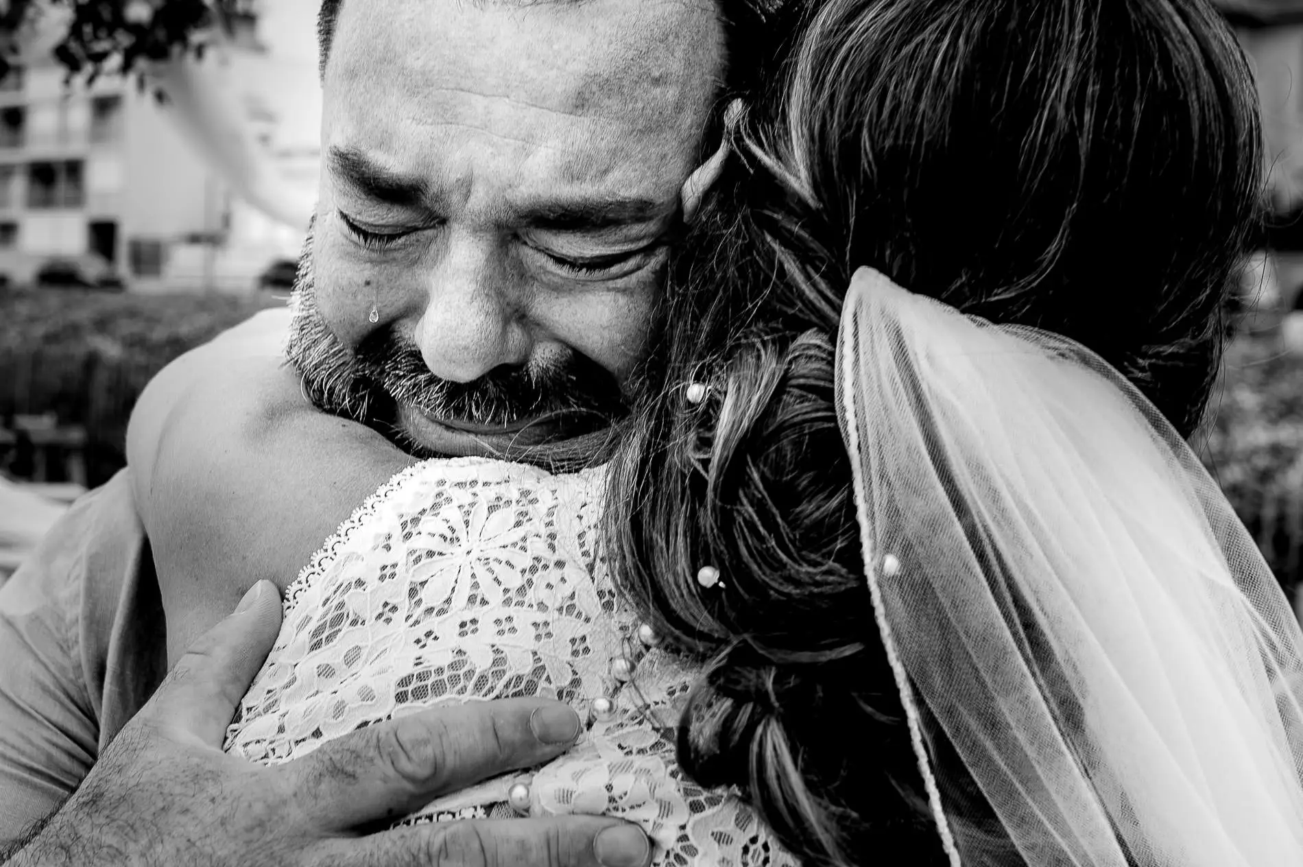 Homme en larmes serrant la mariée dans ses bras moment d’émotion intense mariage Gironde photo noir et blanc